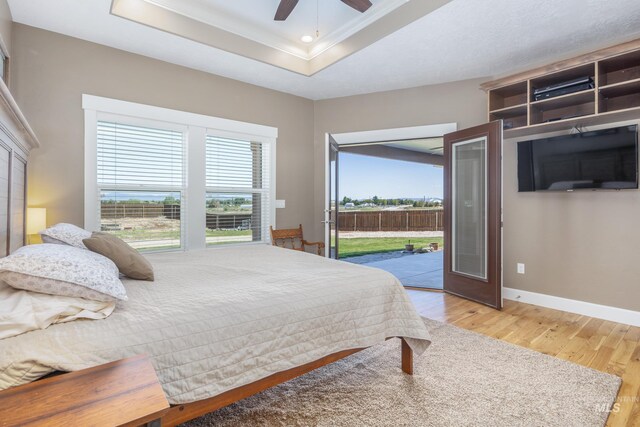 120 S Marko Ln, Kuna, ID 83634 - bedroom with access to exterior, wood finished floors, a tray ceiling, baseboards, and crown molding