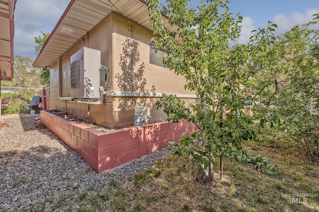 view of side of property with ac unit and fence