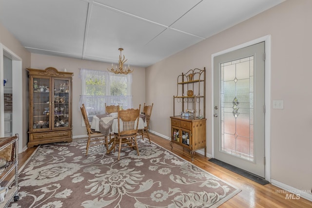 dining room with baseboards, a chandelier, and wood finished floors