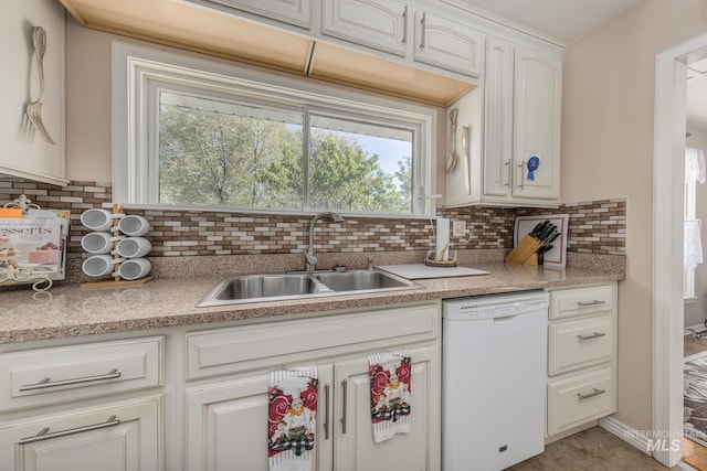 kitchen featuring light countertops, decorative backsplash, a sink, and dishwasher