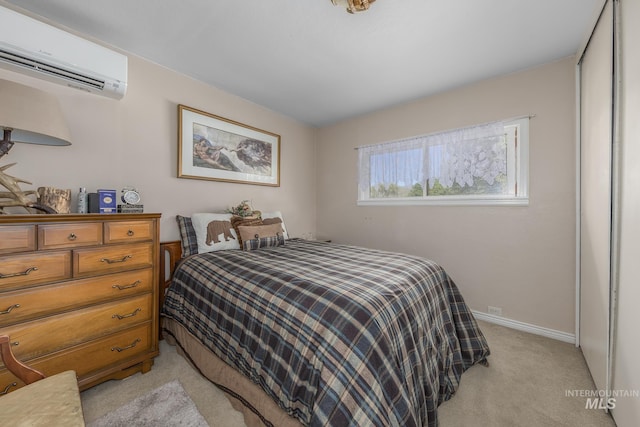 bedroom with baseboards, light carpet, and a wall unit AC