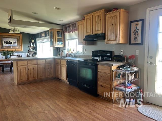 16 E 300 S Unit 16E 300S, Fairfield, ID 83327 - kitchen with black appliances, under cabinet range hood, light wood finished floors, a peninsula, and glass insert cabinets