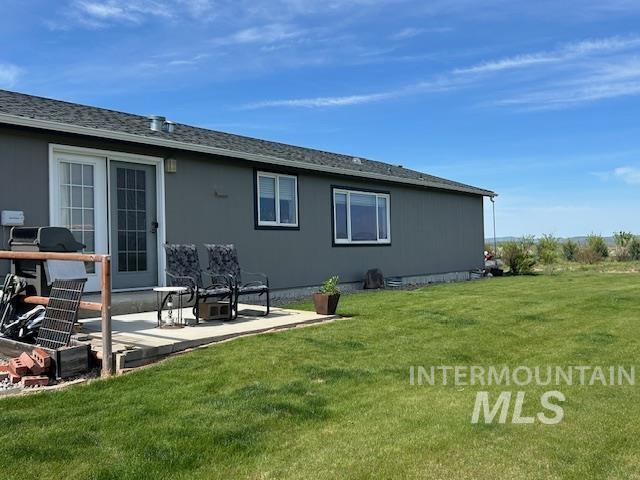 16 E 300 S Unit 16E 300S, Fairfield, ID 83327 - back of house featuring a lawn, a patio area, and a shingled roof
