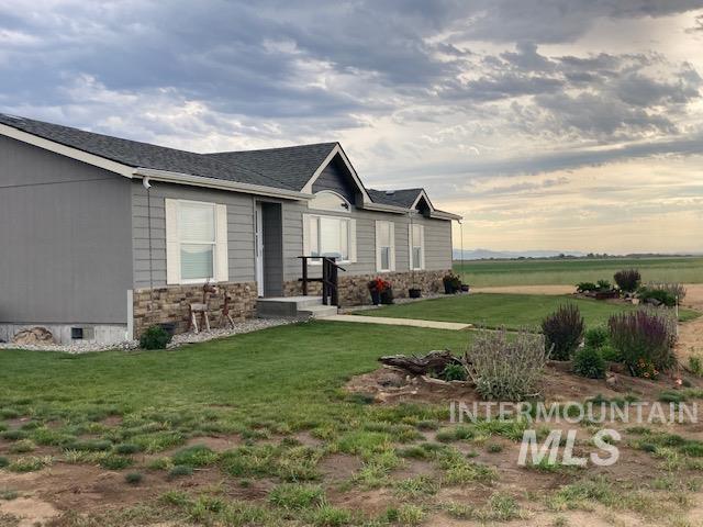 16 E 300 S Unit 16E 300S, Fairfield, ID 83327 - view of property exterior featuring a lawn, stone siding, and roof with shingles