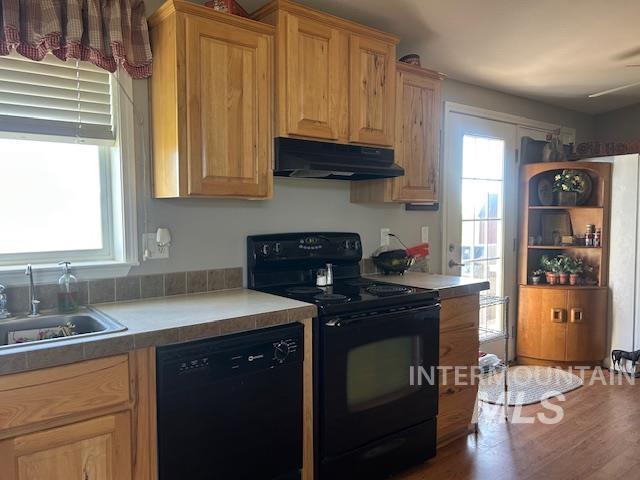16 E 300 S Unit 16E 300S, Fairfield, ID 83327 - kitchen with black appliances, under cabinet range hood, a sink, wood finished floors, and light countertops