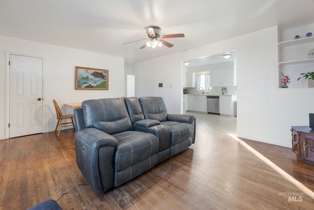 living room featuring ceiling fan, wood-type flooring, and sink