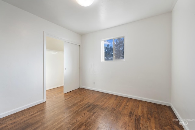 spare room with dark wood-type flooring