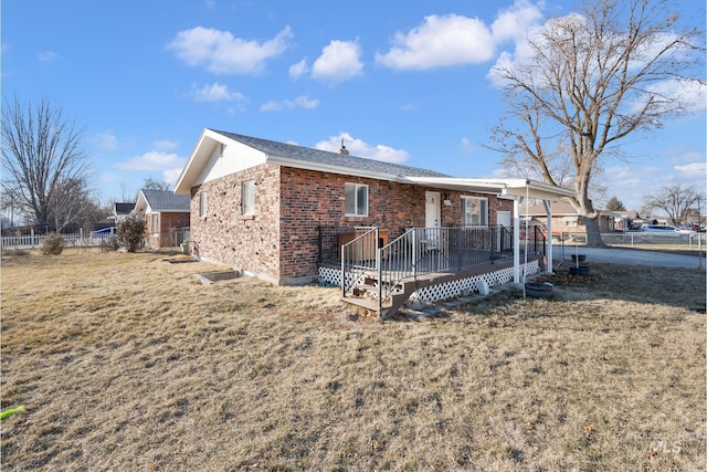 back of property with a yard and a deck