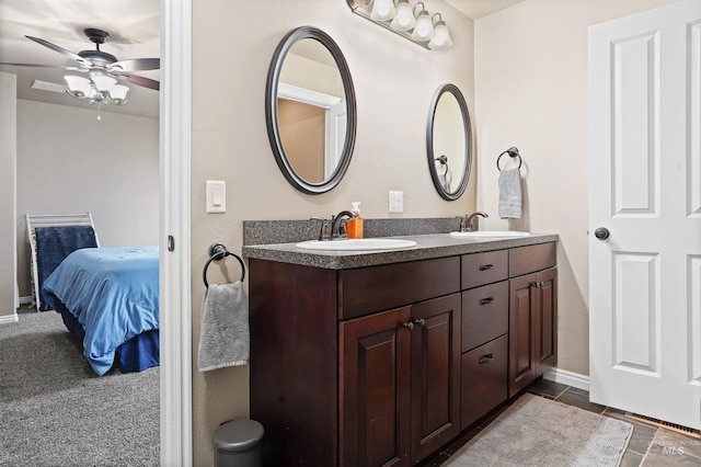 full bathroom with double vanity, a ceiling fan, a sink, and ensuite bathroom