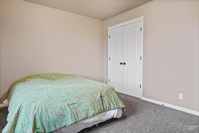 carpeted bedroom featuring a closet and baseboards