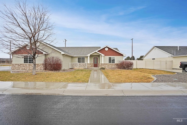 view of front of property with stone siding, fence, and a front lawn