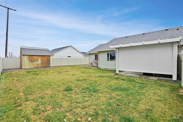 view of yard with a storage shed, an outbuilding, and a fenced backyard