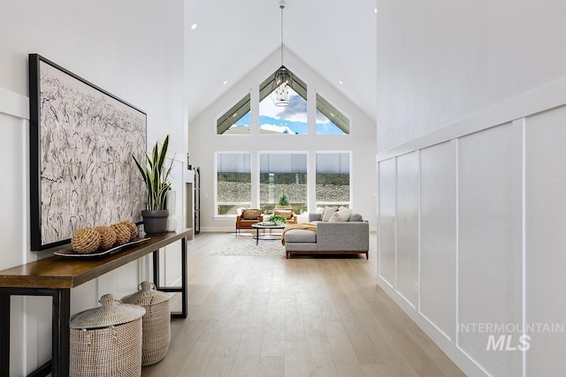 unfurnished room featuring light wood finished floors and a towering ceiling