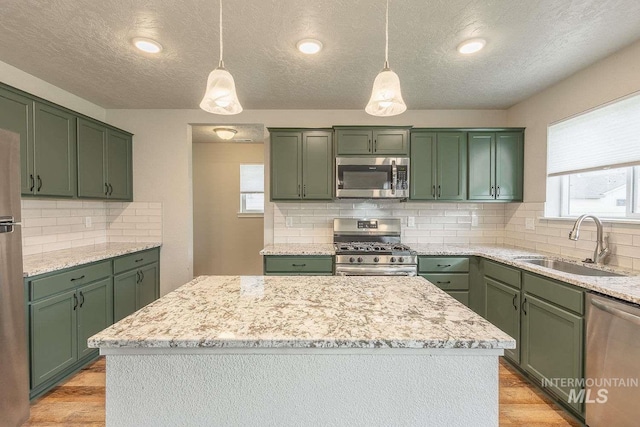 7666 E Lightfoot St, Nampa, ID 83687 - kitchen featuring stainless steel appliances, green cabinetry, a sink, a textured ceiling, and healthy amount of natural light
