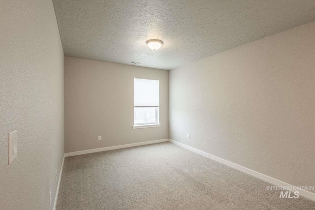 7666 E Lightfoot St, Nampa, ID 83687 - spare room with light carpet, baseboards, a textured ceiling, and a textured wall