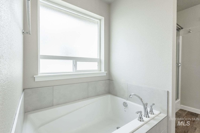 7666 E Lightfoot St, Nampa, ID 83687 - full bath featuring a bath, wood finished floors, and a textured wall