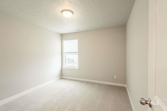 7666 E Lightfoot St, Nampa, ID 83687 - empty room featuring light carpet, baseboards, and a textured ceiling