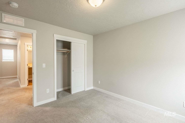 7666 E Lightfoot St, Nampa, ID 83687 - unfurnished bedroom featuring light carpet, a closet, baseboards, and a textured ceiling