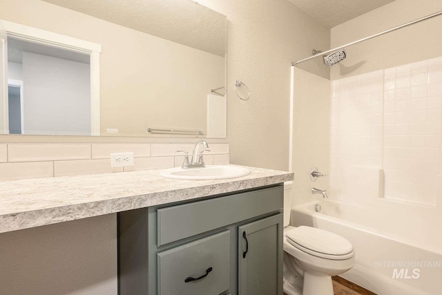 7666 E Lightfoot St, Nampa, ID 83687 - full bath with toilet, vanity, tub / shower combination, a textured wall, and decorative backsplash