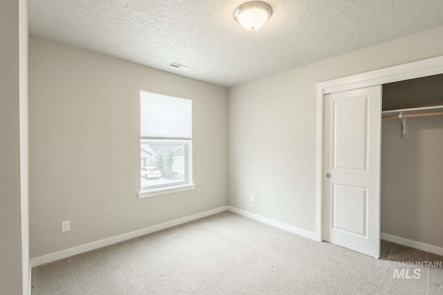 7666 E Lightfoot St, Nampa, ID 83687 - unfurnished bedroom featuring carpet floors, a closet, a textured ceiling, and baseboards