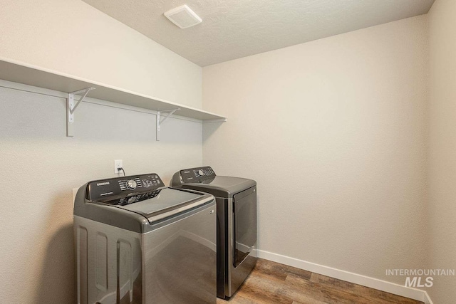 7666 E Lightfoot St, Nampa, ID 83687 - laundry area featuring washing machine and clothes dryer, dark wood-type flooring, and baseboards