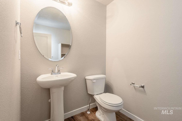 7666 E Lightfoot St, Nampa, ID 83687 - bathroom with wood finished floors, toilet, a sink, and baseboards