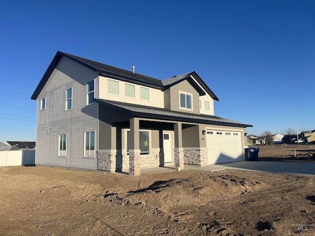traditional-style house with an attached garage, stone siding, fence, a porch, and driveway