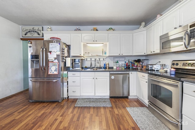 706 Utah St, Gooding, ID 83330 - kitchen with stainless steel appliances, a sink, dark countertops, white cabinetry, and dark wood-type flooring