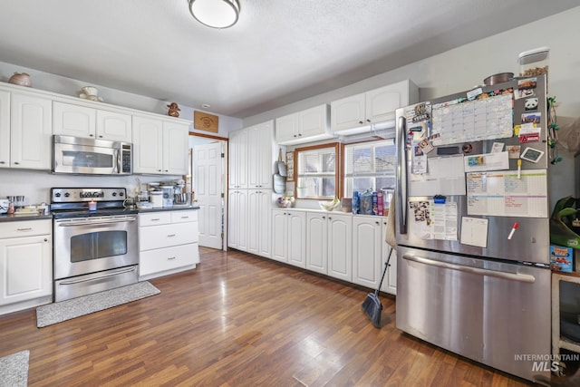 706 Utah St, Gooding, ID 83330 - kitchen with appliances with stainless steel finishes, white cabinetry, dark countertops, and dark wood-type flooring