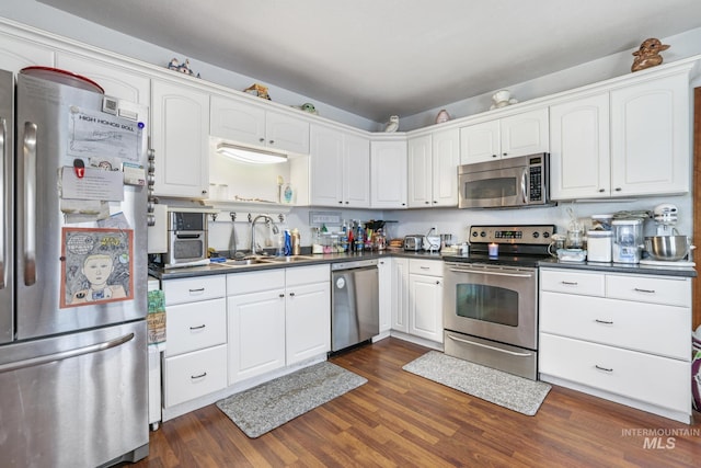 706 Utah St, Gooding, ID 83330 - kitchen featuring appliances with stainless steel finishes, a sink, dark countertops, and dark wood-style flooring