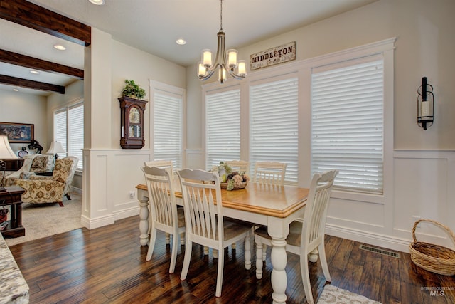 dining room featuring dark hardwood / wood-style flooring, beam ceiling, and a chandelier