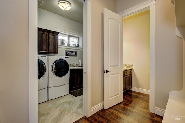 washroom with hardwood / wood-style flooring, cabinets, and separate washer and dryer