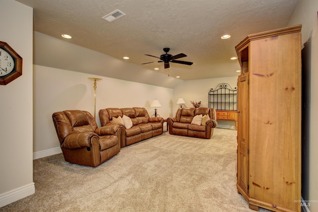 living room with ceiling fan, light colored carpet, lofted ceiling, and a textured ceiling