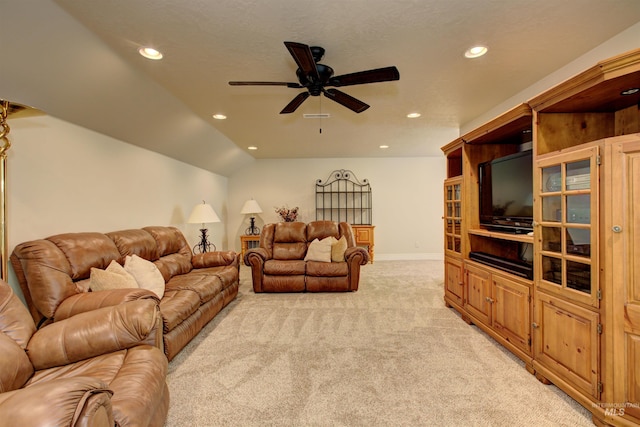 living room featuring vaulted ceiling, light carpet, a textured ceiling, and ceiling fan