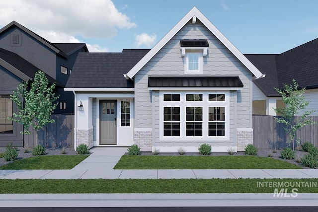 view of front facade featuring a standing seam roof, stone siding, fence, and metal roof