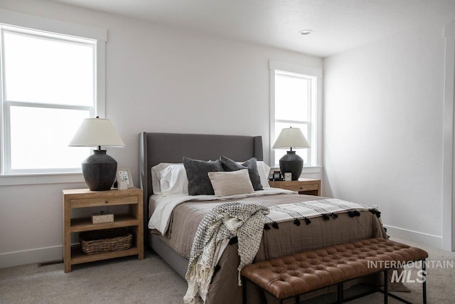 carpeted bedroom with multiple windows and baseboards