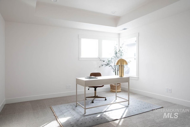 carpeted office with a raised ceiling, visible vents, and baseboards