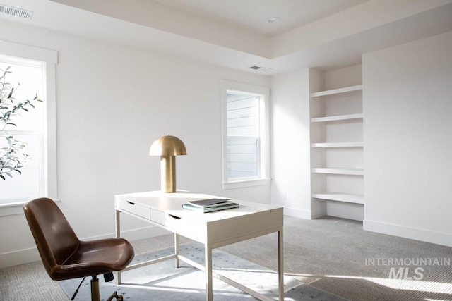 home office featuring a wealth of natural light, carpet flooring, visible vents, and baseboards