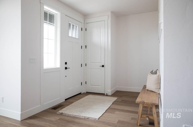 entrance foyer with visible vents, baseboards, and wood finished floors