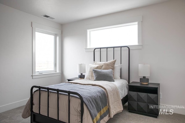 carpeted bedroom with multiple windows, visible vents, and baseboards