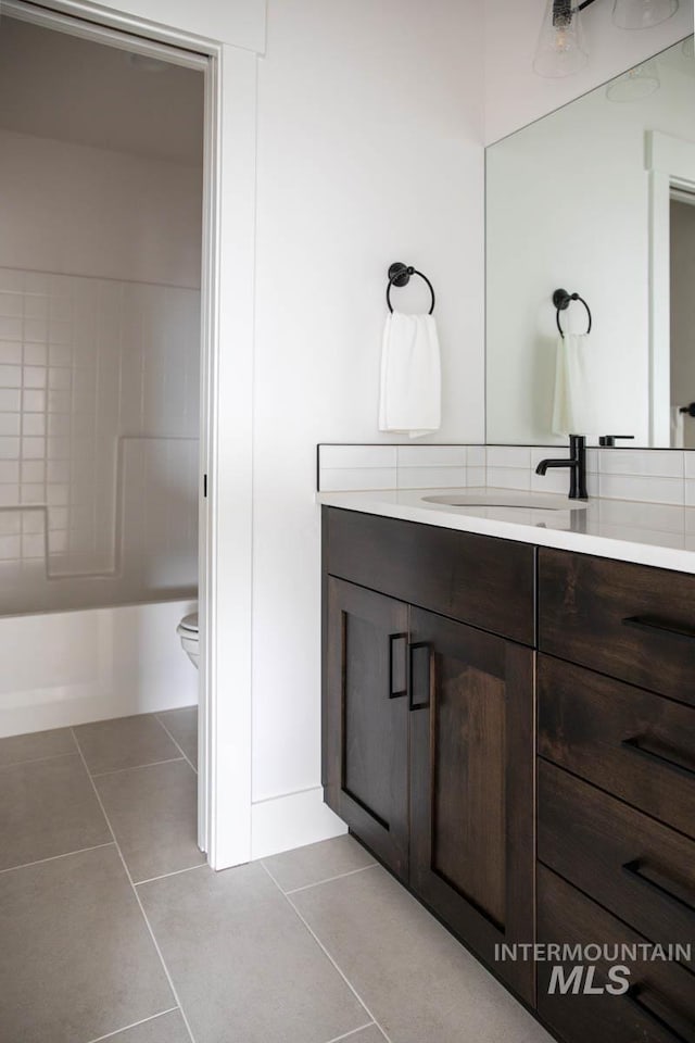 full bath with tile patterned flooring, vanity, and toilet