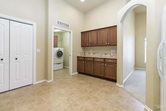 421 N David Frost St, Nampa, ID 83651 - laundry area featuring cabinet space, washer / clothes dryer, arched walkways, a towering ceiling, and baseboards