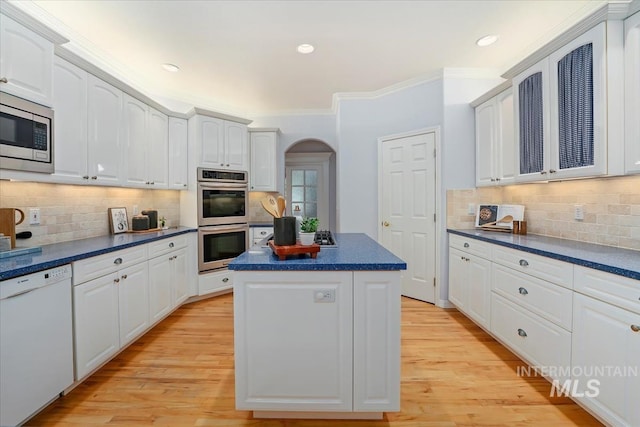 2368 SE 5th Way, Meridian, ID 83642 - kitchen featuring stainless steel appliances, dark countertops, arched walkways, a kitchen island, and crown molding