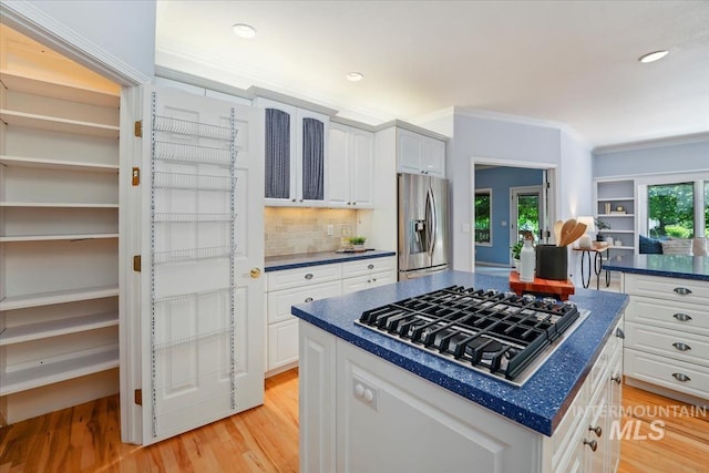 2368 SE 5th Way, Meridian, ID 83642 - kitchen with stainless steel appliances, dark countertops, light wood-style floors, a center island, and white cabinets