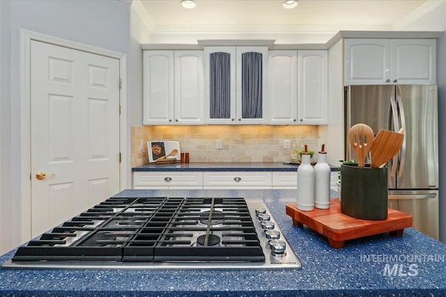 2368 SE 5th Way, Meridian, ID 83642 - kitchen with appliances with stainless steel finishes, dark countertops, tasteful backsplash, ornamental molding, and white cabinetry