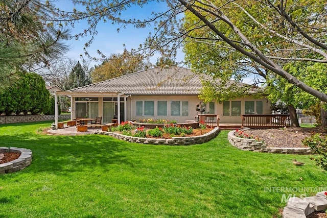 2368 SE 5th Way, Meridian, ID 83642 - rear view of house featuring a sunroom, a lawn, a wooden deck, a tiled roof, and stucco siding