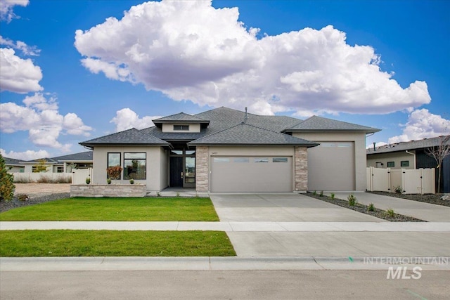 prairie-style house featuring a front lawn and a garage