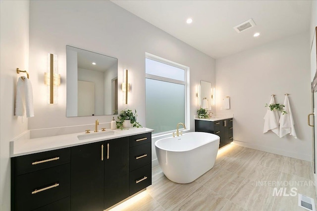 bathroom with a tub and vanity