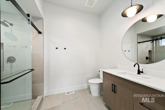 bathroom featuring tile patterned flooring, vanity, toilet, and a shower with door