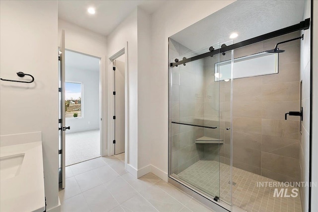 bathroom with tile patterned flooring, vanity, and a shower with shower door